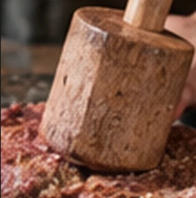 Illustrative close-up of a wooden pounder working minced beef into paste