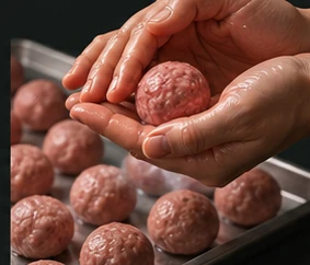 Illustrative close-up of hands shaping a meatball