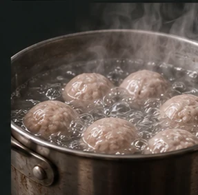 Illustrative close-up of meatballs in hot water during cooking
